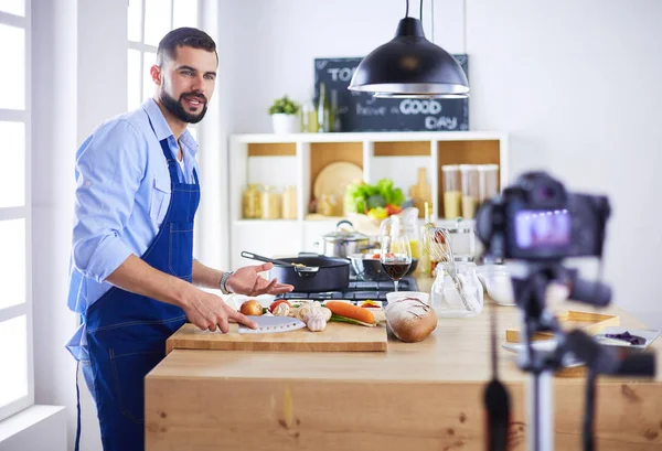 Man holding paper bag full of groceries on the kitchen background. Shopping and healthy food concept — Stock Photo, Image