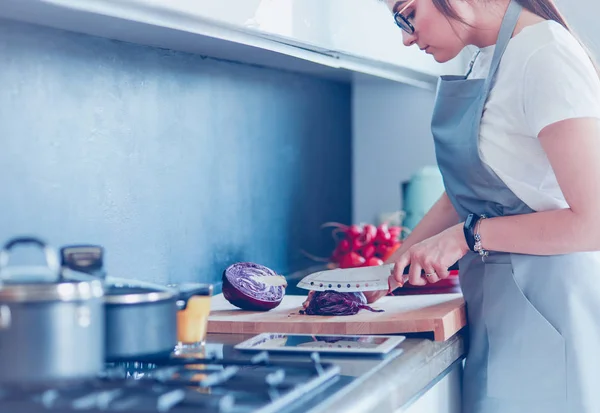 Yeni mutfakta yemek pişiren kadın sebzelerle sağlıklı yemekler yapıyor. — Stok fotoğraf