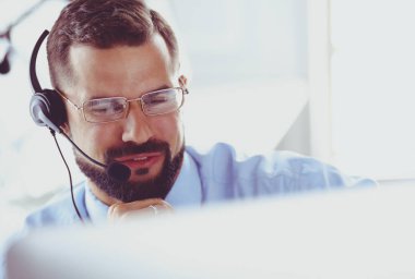 Bilgisayarın önünde kulaklık takmış genç bir adamın portresi.