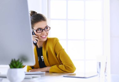 ofis telefon laptop ile oturuyor ve iş kadını