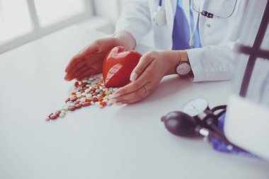 Masada kırmızı kalbi ve steteskopu olan kardiyolog.