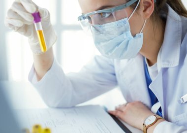 Modern laboratuvar veya hastanede plastik tıbbi tüplerle çalışan araştırmacı, doktor, bilim adamı veya laboratuvar asistanı