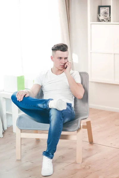 Schöner selbstbewusster Mann sitzt zu Hause im Sessel — Stockfoto