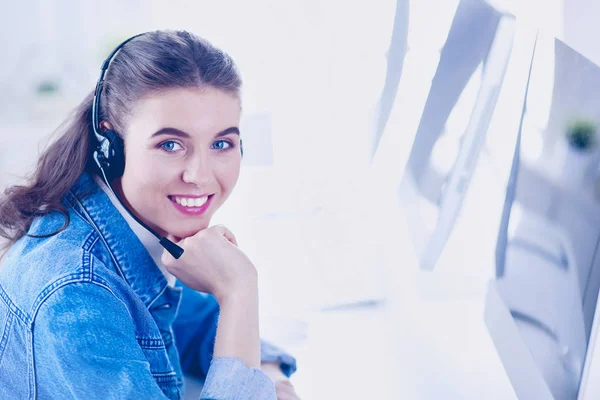 Retrato de mulher de negócios bonita trabalhando em sua mesa com fone de ouvido e laptop — Fotografia de Stock