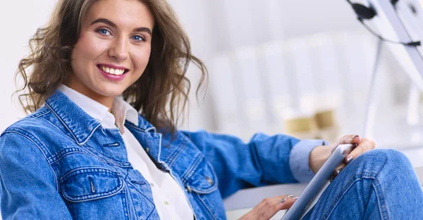 Mujer sonriente bebiendo café y usando la tableta en el café — Foto de Stock