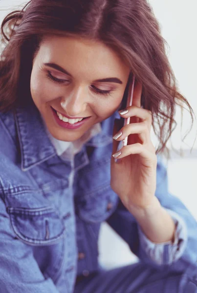 Mujer joven en la cafetería bebiendo café y hablando por teléfono móvil — Foto de Stock