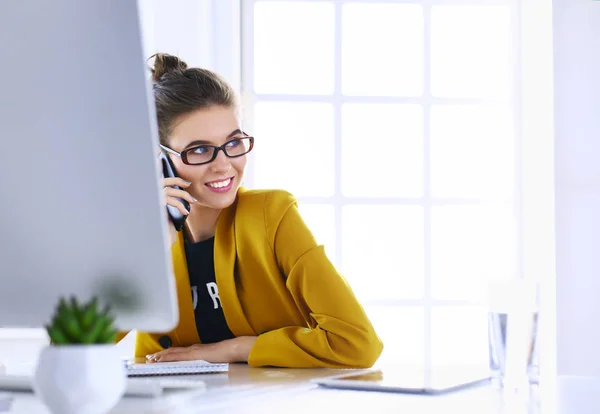 Zakenvrouw zitten in kantoor met laptop op telefoon — Stockfoto