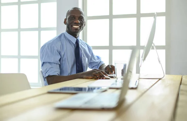 Afrikansk amerikansk affärsman på headset arbetar på sin bärbara dator — Stockfoto