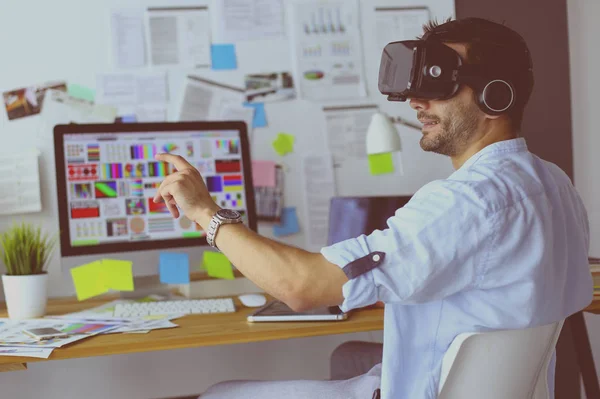 Young male software programmer testing a new app with 3d virtual reality glasses in office.