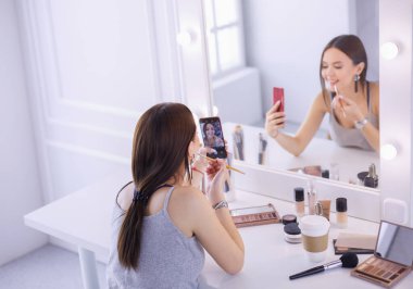 Ayna önünde akıllı telefon ile makyaj eğitimi filme Güzellik blogger