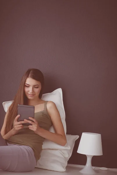 Mulher sentada no chão usando um tablet digital — Fotografia de Stock