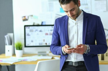 Dizüstü bilgisayar ve bilgisayar çalışırken önünde genç tasarımcı portresi.