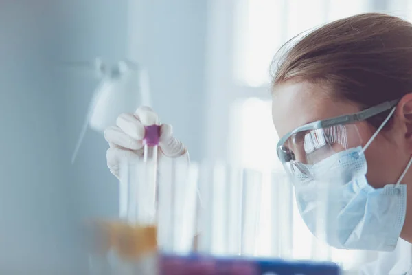 Chercheur médical ou scientifique ou médecin examinant une éprouvette de solution verte liquide dans un laboratoire — Photo