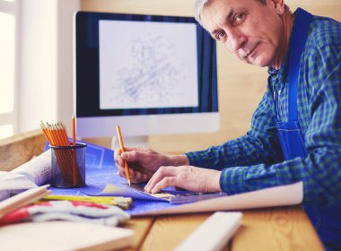 Ofisteki çizim masasında çalışan mimar