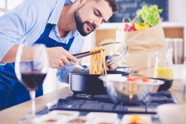 Adam ev mutfağında lezzetli ve sağlıklı yemekler hazırlıyor.