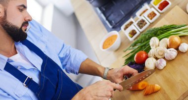 Adam ev mutfağında lezzetli ve sağlıklı yemekler hazırlıyor.