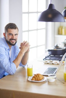 Adam ev mutfağında lezzetli ve sağlıklı yemekler hazırlıyor.