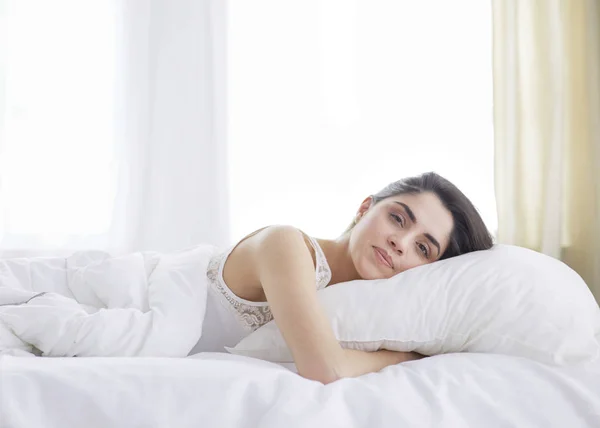 Mulher bonita deitada em sua cama em casa — Fotografia de Stock