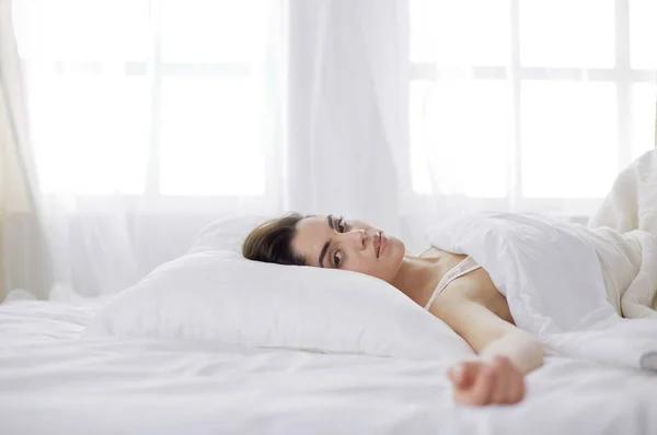 Hübsche Frau legt sich zu Hause auf ihr Bett — Stockfoto