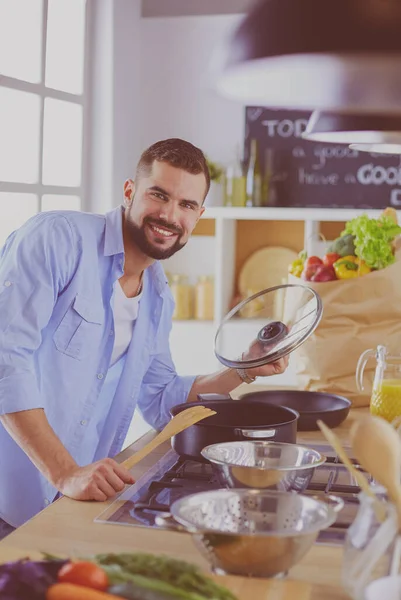 Dijital tablet ve yemek pişirme tarifine uyan bir adam evdeki mutfakta lezzetli ve sağlıklı yemekler pişiriyor. — Stok fotoğraf