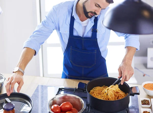 家のキッチンでおいしいと健康食品を準備する男 — ストック写真