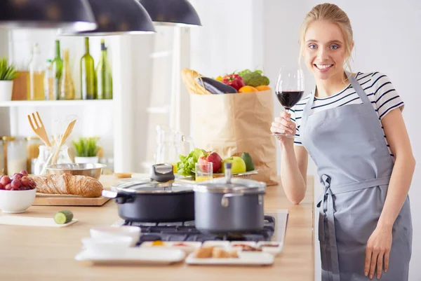 Hübsche Frau trinkt zu Hause Wein in Küche — Stockfoto