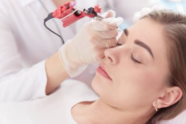 Kırmızı dudaklı genç bir kız kalıcı makyaj, mikro pigmentasyon