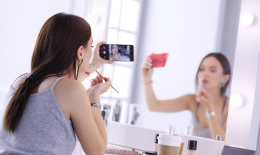 Ayna önünde akıllı telefon ile makyaj eğitimi filme Güzellik blogger