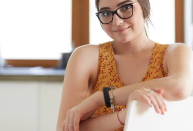 Mutfakta masada oturan genç bir kadın.