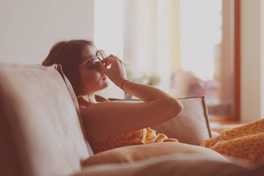 Evdeki modern bir kanepede oturan rahat kadın.