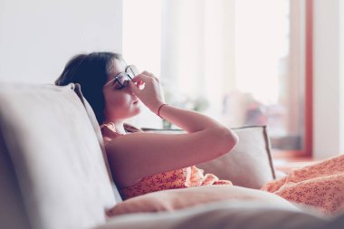 Evdeki modern bir kanepede oturan rahat kadın.