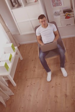 Mutlu adam masada oturan ve dizüstü evde kullanma