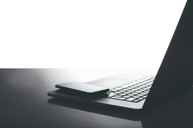 Bilgisayarı ve ahşap masasında akıllı telefonu olan bir ofis.