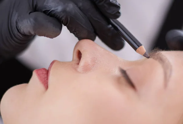 Cosmetólogo aplicando maquillaje permanente en las cejas —  Fotos de Stock