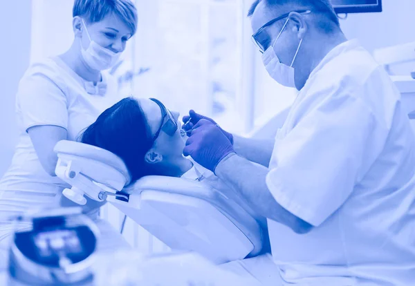 Man dentist working at his patients teeth — Stock Photo, Image