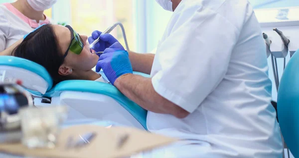 Portrait of a dentist who treats teeth of young woman patient — Stock Photo, Image