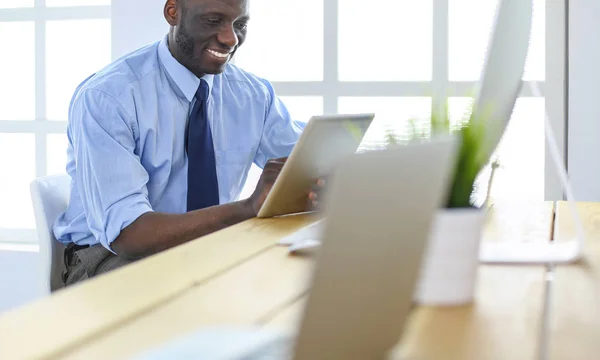 Afrikansk amerikansk affärsman på headset arbetar på sin bärbara dator — Stockfoto