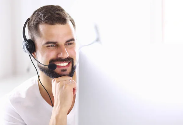 Portrait of a young man with a headset in front of a laptop computer — Stock Photo, Image