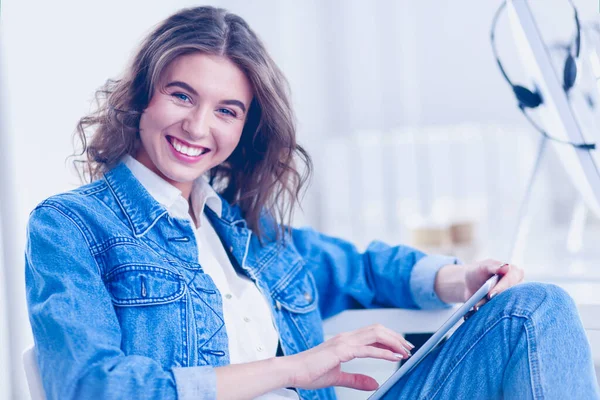 Mujer sonriente bebiendo café y usando la tableta en el café — Foto de Stock