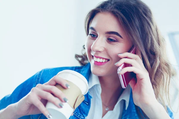 Junge Frau im Café trinkt Kaffee und telefoniert — Stockfoto