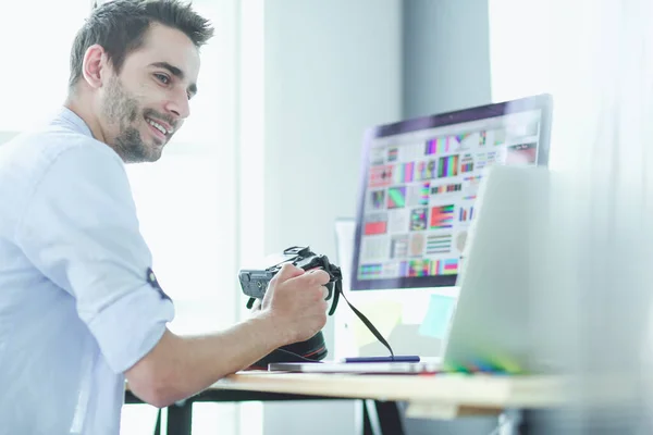 Retrato de jovem designer sentado no estúdio gráfico na frente de laptop e computador enquanto trabalhava online. — Fotografia de Stock