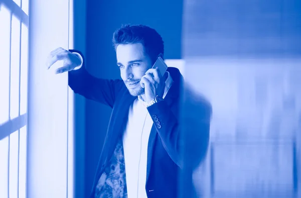 Retrato de jovem designer na frente de laptop e computador enquanto trabalhava . — Fotografia de Stock