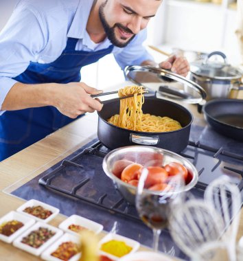 Adam ev mutfağında lezzetli ve sağlıklı yemekler hazırlıyor.