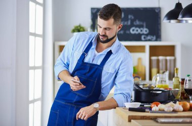 Mutfak arka planında poşet dolusu erzak tutan adam. Alışveriş ve sağlıklı gıda konsepti