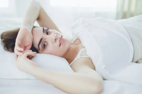 Mulher bonita deitada em sua cama em casa — Fotografia de Stock