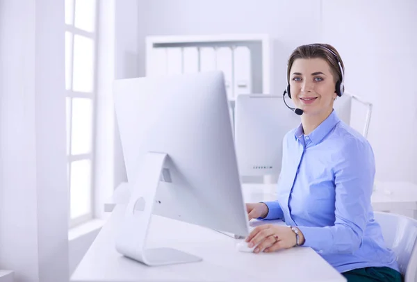 Serious pretty young woman working as support phone operator with headset in office — Stock Photo, Image