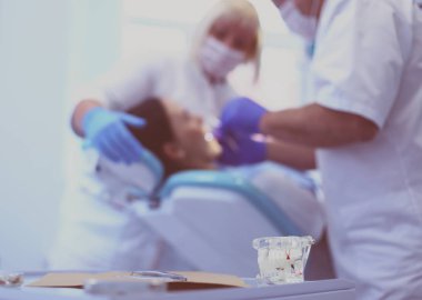 Diş hekimi ve asistanı kapsamlı bir muayene yapıyorlar.