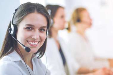 Ofisinde kulaklık ve bilgisayarla gülümseyen iş kadını ya da yardım hattı operatörü