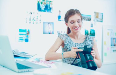 Genç kadın fotoğrafçı kameradan ön gösterimleri kontrol ediyor.