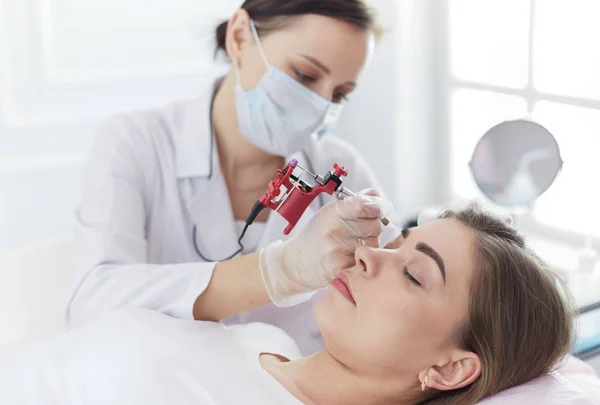 A young girl having red lips permanent makeup, micropigmentation — Stock Photo, Image